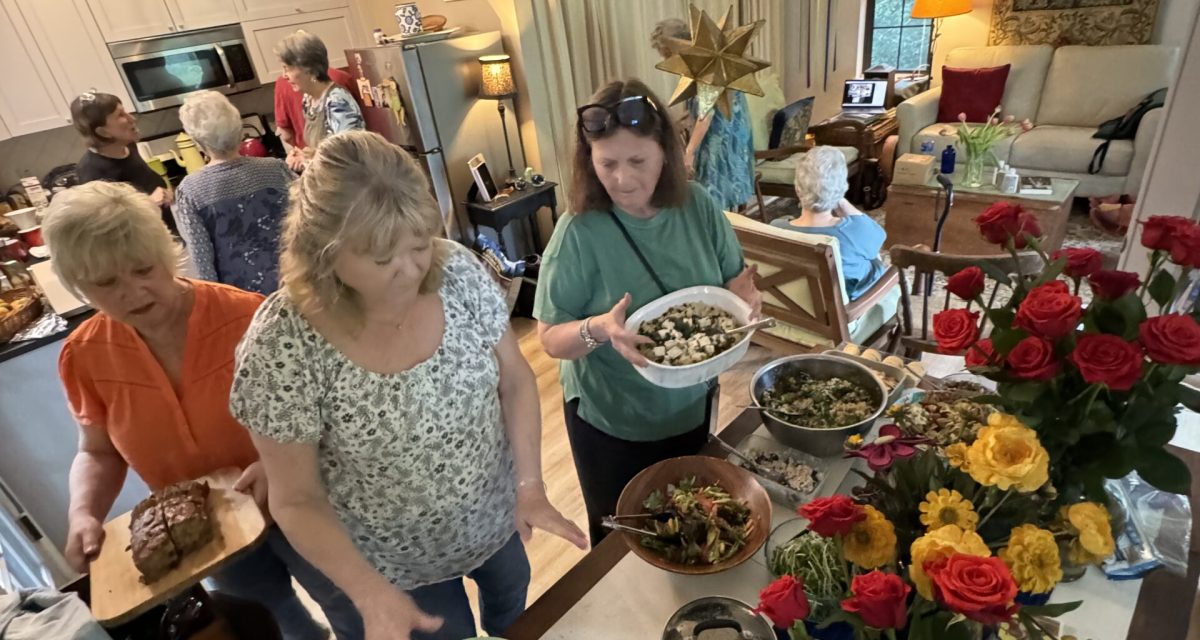 Gathering at a recent retreat at Wild Hare Abbey. Members prepare lunch with red and yellow roses in the foreground.